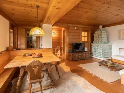a living room with a wooden table and a fireplace at Casa La Montanina, a due passi dal centro di Cortina in Cortina dʼAmpezzo