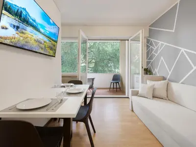 a living room with a white table and a couch at Central Palm Studio with free Parking in Merano