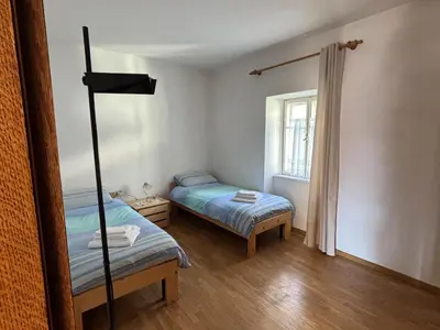 a small room with two beds and a window at Casa Tone in Predazzo