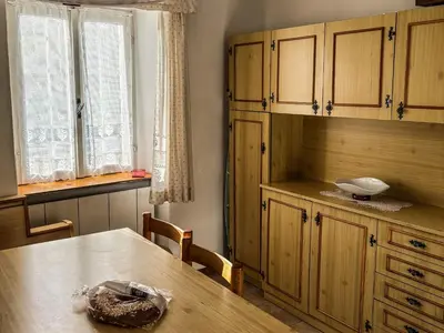 a kitchen with wooden cabinets and a table with a bowl on it at Casa Tone in Predazzo