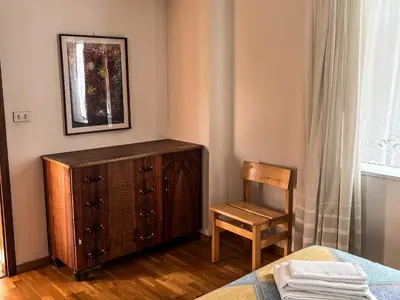 a bedroom with a wooden dresser and a chair at Casa Tone in Predazzo