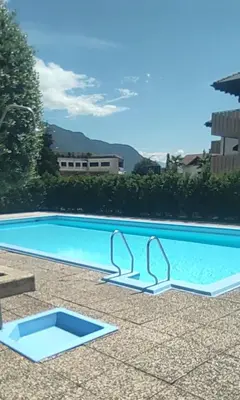a large swimming pool with a blue water at Lovely Apartment with pool and garden in Marlengo