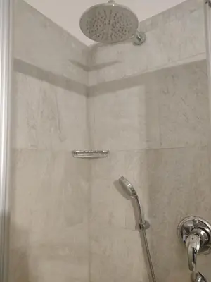 a shower with a glass door in a bathroom at Lovely Apartment with pool and garden in Marlengo