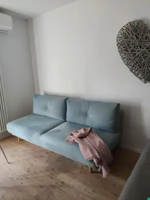 a blue couch sitting in a living room at Lovely Apartment with pool and garden in Marlengo