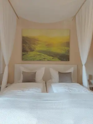 a bedroom with two beds and a painting on the wall at Apartment Bergblick auf Bio-Hof in Merano
