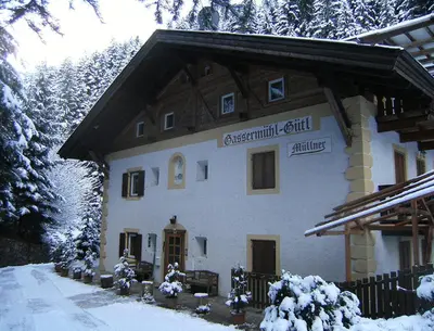 a building with a sign on it in the snow at Privatzimmer Gassermühle in Eggen