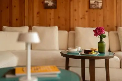 a living room with a couch and a table with a vase of flowers at Pergola Residence in Lagundo