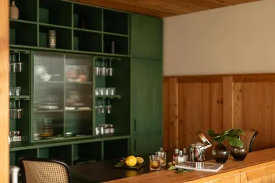 a dining room with green walls and a table with chairs at Pergola Residence in Lagundo