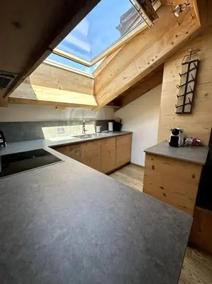 a kitchen with a counter top and a large window at Attico Bellavista in Cortina dʼAmpezzo