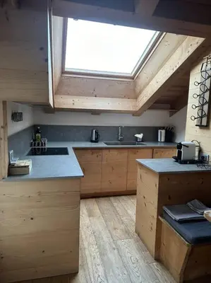 a large kitchen with a skylight in the ceiling at Attico Bellavista in Cortina dʼAmpezzo