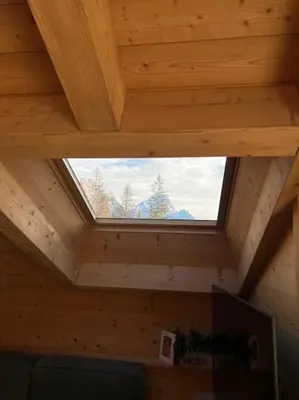 a window in the ceiling of a wooden cabin at Attico Bellavista in Cortina dʼAmpezzo