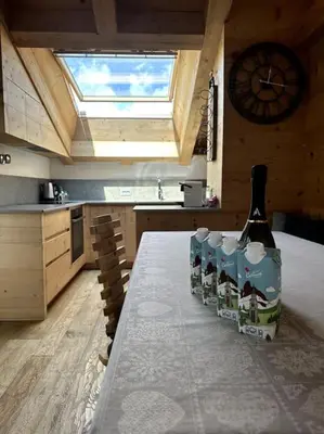 a bottle of wine sitting on a table in a kitchen at Attico Bellavista in Cortina dʼAmpezzo