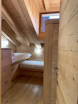 a wooden cabin with two bunk beds in it at Attico Bellavista in Cortina dʼAmpezzo