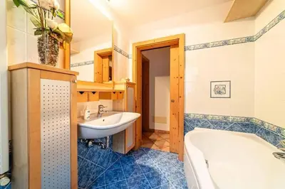 a bathroom with a tub and a sink at Casa di Sere in Pieve di Livinallongo