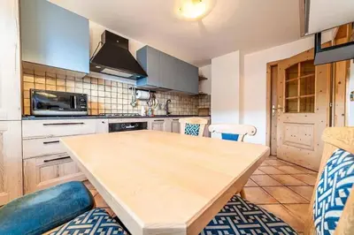 a kitchen with a wooden table in a kitchen at Casa di Sere in Pieve di Livinallongo