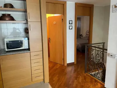a kitchen with a microwave and a door to a room at Da NOEMI E MARCO in Cavalese