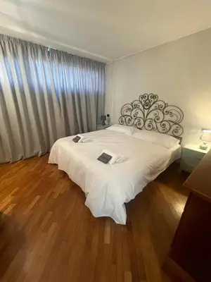 a bedroom with a large white bed with a book on it at Da NOEMI E MARCO in Cavalese