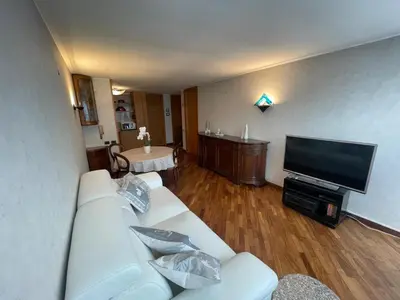 a living room with a white couch and a flat screen tv at Da NOEMI E MARCO in Cavalese