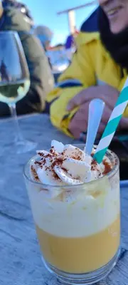 a drink sitting on a table next to a wine glass at Da NOEMI E MARCO in Cavalese