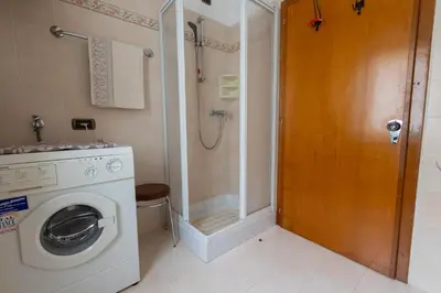 a bathroom with a washing machine and a shower at Dolomites Apartment Finestra sul Civetta in Alleghe