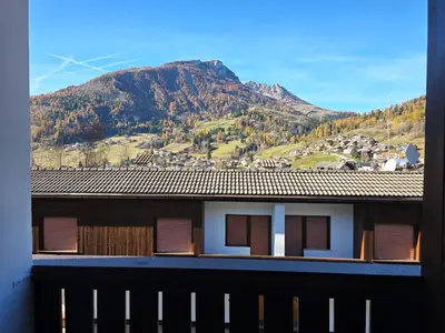 a view of a house with a mountain in the background at Sogno sulle Dolomiti - Alpine Stay Apartments in Moena