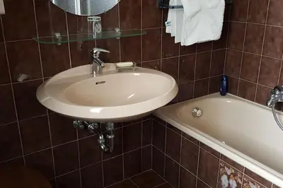 a bathroom with a sink and a bath tub at Kleine Wohnung, großer Garten! in Merano
