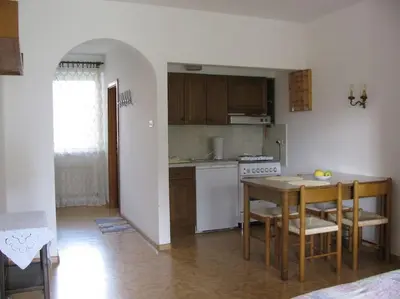 a kitchen with a table and chairs and a dining room at Kleine Wohnung, großer Garten! in Merano