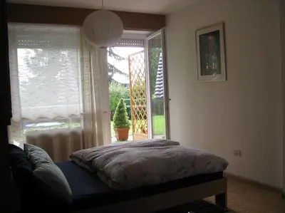 a bedroom with a bed in front of a window at Kleine Wohnung, großer Garten! in Merano