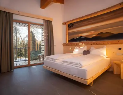 a bedroom with a large bed and a large window at Residence Lavina in Caldaro