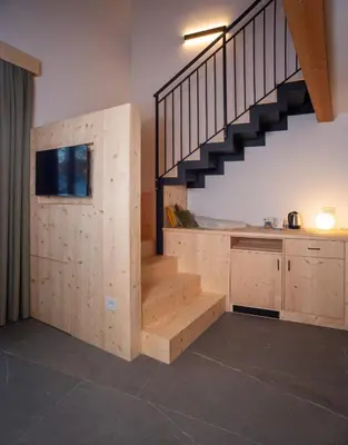 a large living room with a staircase and a table at Residence Lavina in Caldaro