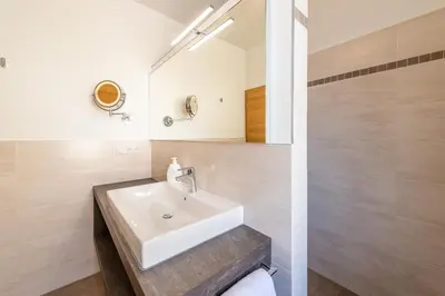 a bathroom with a white sink and a mirror at Ferienhof Franzelin in Termeno