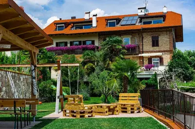 a house with a garden with chairs in front of it at Ferienhof Franzelin in Termeno