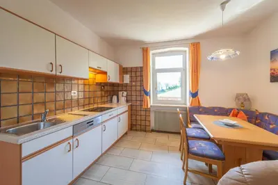 a kitchen with a table and a sink and a table and chairs at Ferienhof Franzelin in Termeno