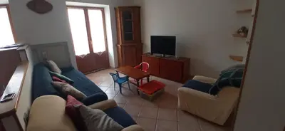 a living room with a blue couch and a table at CasaSandra-Tres-Trentino in Tres