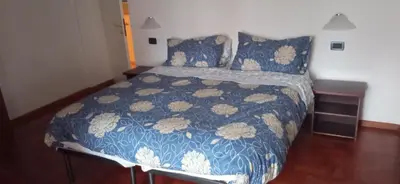 a bedroom with a bed with a blue and white comforter at CasaSandra-Tres-Trentino in Tres