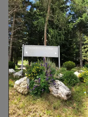 a sign in a garden with flowers and rocks at Camera Alpe di Siusi in Alpe di Siusi