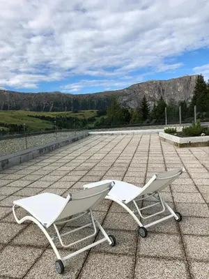 two white chairs sitting on top of a roof at Camera Alpe di Siusi in Alpe di Siusi