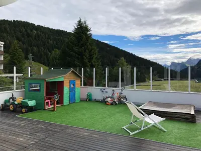 a backyard with a toy house and a playground at Camera Alpe di Siusi in Alpe di Siusi