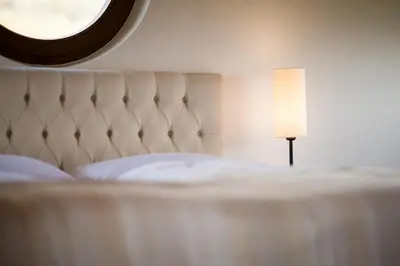 a bed with a table with a lamp on it at Weingut Weidlhof - Suite & Breakfast - Vacation for wine lovers in Caldaro