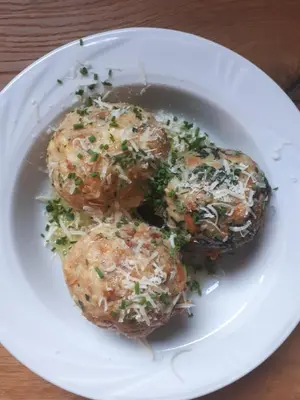 a white plate with three meatballs with cheese and herbs at Weingut Weidlhof - Suite & Breakfast - Vacation for wine lovers in Caldaro