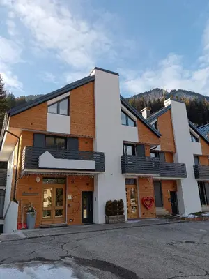 a white building with wood at Appartamento 2 Residenza RODODENDRO in Campitello