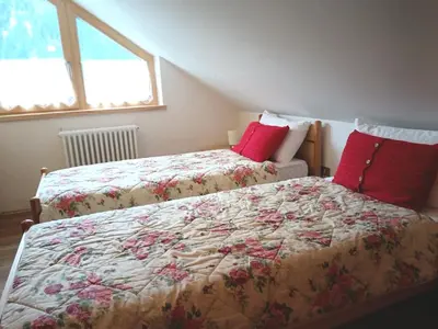 a bedroom with two beds with red pillows at Appartamento 2 Residenza RODODENDRO in Campitello