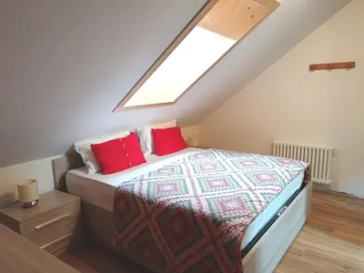 a bedroom with a bed with red pillows at Appartamento 2 Residenza RODODENDRO in Campitello
