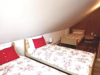 a bedroom with two beds with red pillows at Appartamento 2 Residenza RODODENDRO in Campitello