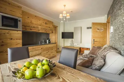 a dining room with a table with a bowl of fruit at Residence Aspen in Arabba