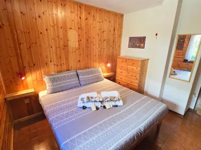 a bedroom with a bed with two towels on it at Fior di Larice - Alpine Stay Apartments in Ziano di Fiemme