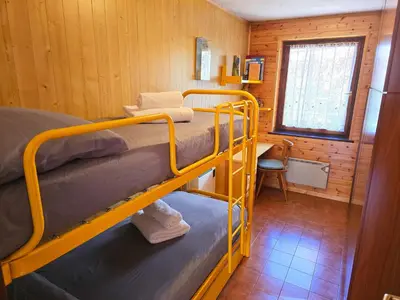 a room with two bunk beds in a cabin at Fior di Larice - Alpine Stay Apartments in Ziano di Fiemme