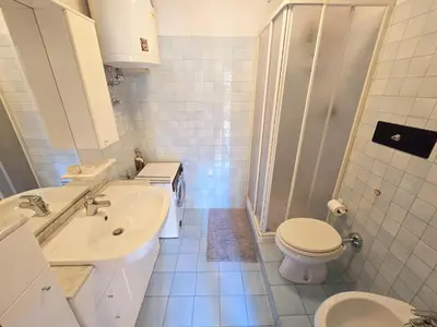 a white bathroom with a toilet and a sink at Fior di Larice - Alpine Stay Apartments in Ziano di Fiemme