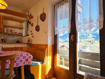 a kitchen with a table and a window at Fior di Larice - Alpine Stay Apartments in Ziano di Fiemme