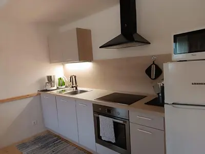 a kitchen with white cabinets and a white refrigerator at Ferienwohnung Marchnerhof in Terento